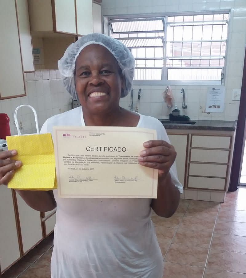 A funcionária da empresa W med,recebendo seu certificado de participação no Curso de Higiene e manipulação de Alimentos.